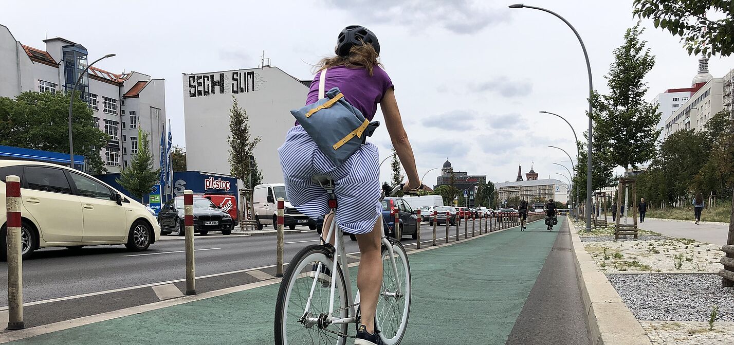 Frau auf geschütztem Radfahrstreifen